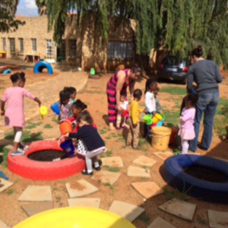 Children filling tyre gardens with soil and water