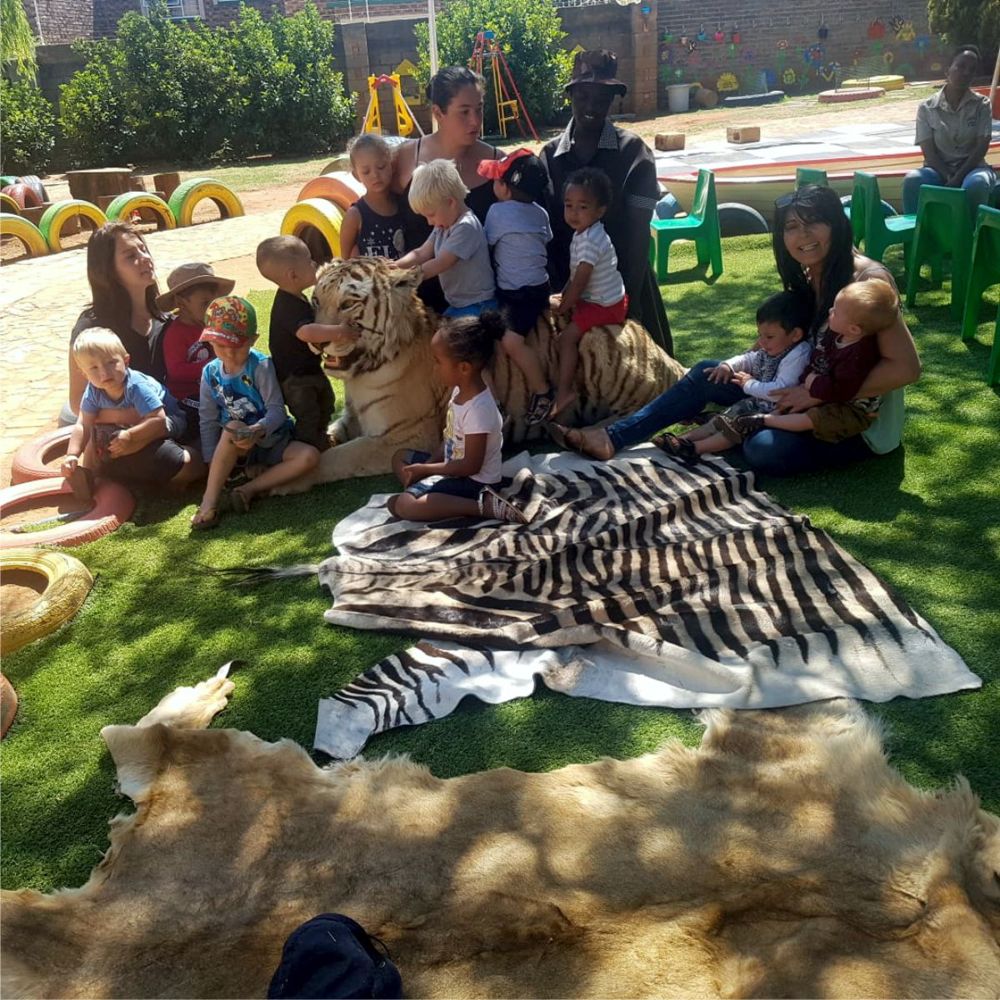 Teachers and children gathered on the lawn for an outdoor lesson