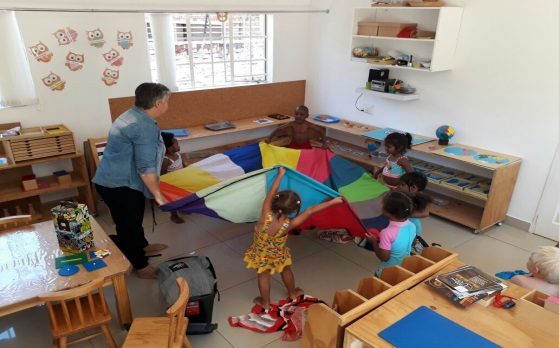 A bright Montessori classroom with low wooden shelves