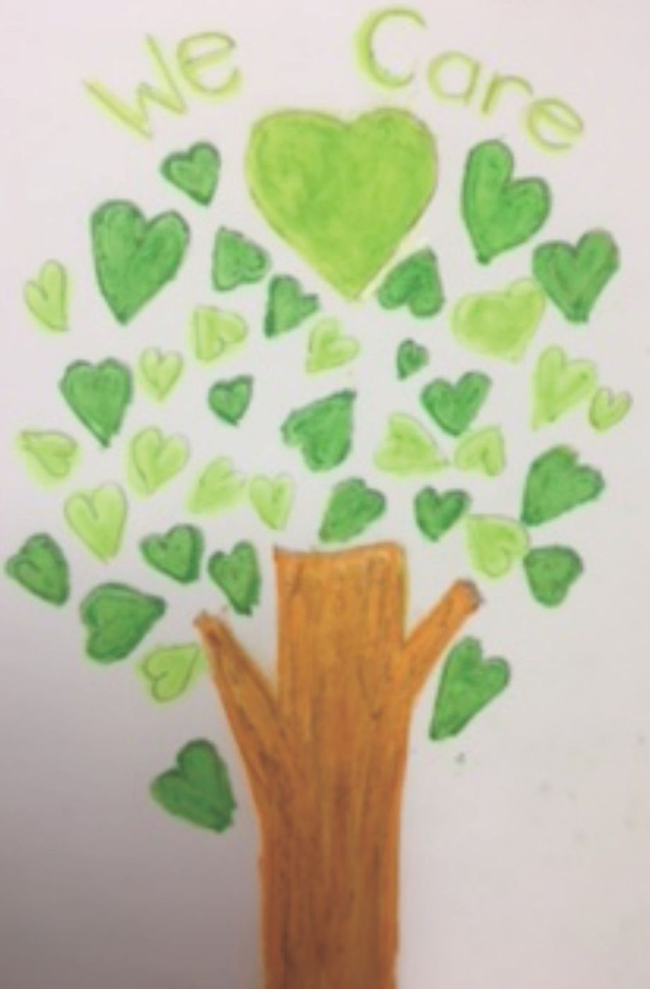 A child's drawing of a tree made of green hearts with the words We Care