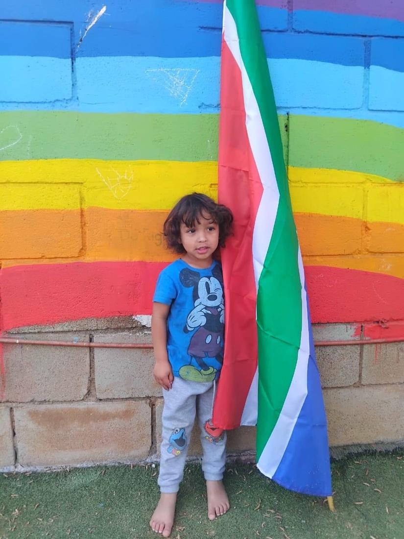 A girl in traditional dress holding the South African flag on Heritage Day